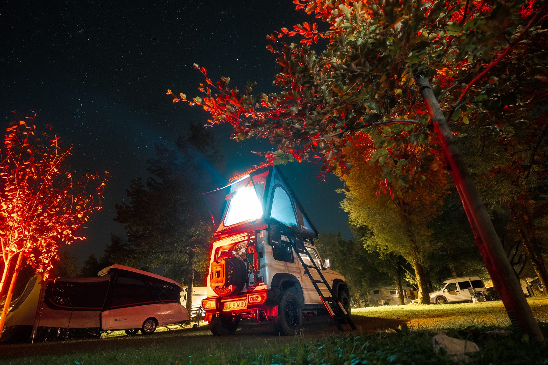 Snailer roof tent lit up at a campsite at night